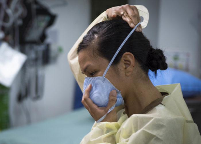 A US Navy nurse puts on a face mask